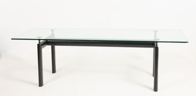 une table en verre avec des pieds noirs et un plateau en verre