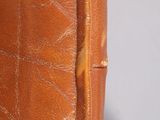an old brown leather suitcase sitting on top of a white table