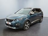 La voiture bleue est garée dans une grande pièce au sol noir.