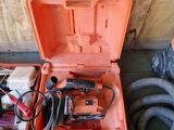 une boîte à outils orange posée par terre, contenant des outils