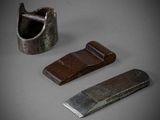 three pieces of metal and wood are sitting on a gray surface