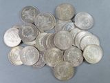 pile of silver coins sitting on top of a gray surface