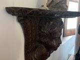 a wooden shelf with a statue on top of it