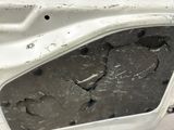 a hole in the door of a car that has been smashed