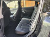 the back seats of a car with the door open and the driver ' s seat down