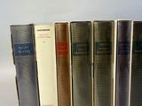 books are lined up in a row on a white surface