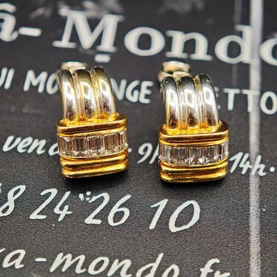 une paire de boucles d'oreilles en or et diamants posée sur un calendrier