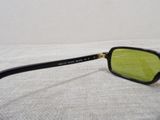 sunglasses on a bed with a white sheet and a white wall in the background