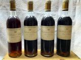 four bottles of wine are lined up on a wooden tray