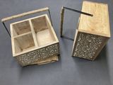Deux boîtes en bois munies de poignées sont posées sur une table.