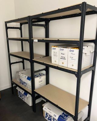 a shelf with boxes and boxes on it in a room
