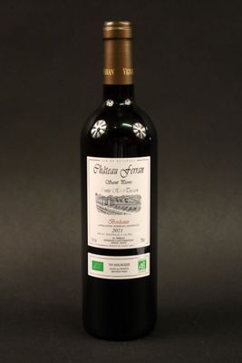 une bouteille de vin rouge posée sur une table noire