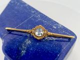 a close up of a blue stone with a gold tie bar