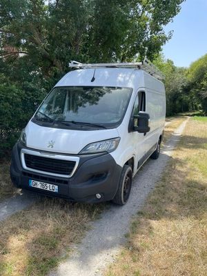 une camionnette blanche garée sur le bord d'un chemin de terre