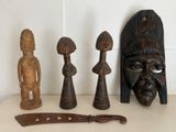 five wooden figurines and a knife on a table