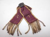 an image of a purple scarf with gold fringes and a button on it