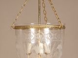 a glass hanging light that is hanging from the ceiling