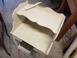 a small table with a drawer on it in the middle of a room
