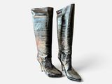 a pair of metallic boots on a white background