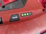 a close up of a gas button on a red lawn mower