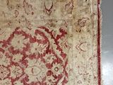an old rug with a red design on it