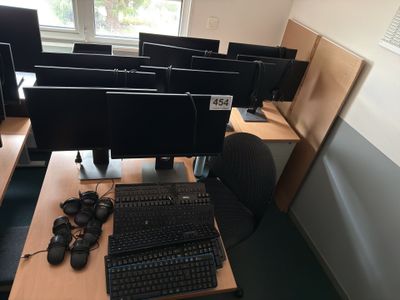 many computer screens and keyboards on the desk in this room