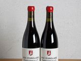 deux bouteilles de vin rouge posées sur une table en bois