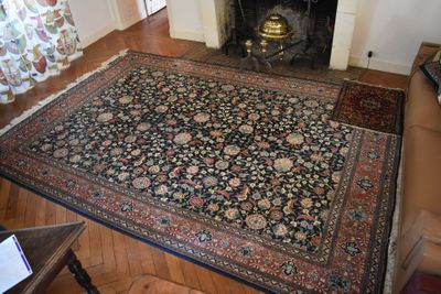 a living room with a fireplace and a rug on the floor