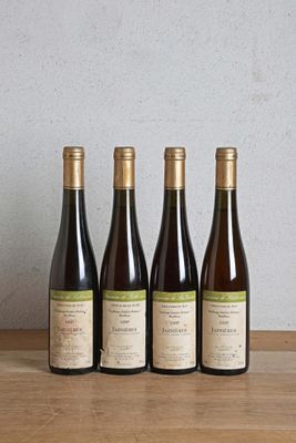 trois bouteilles de vin sont alignées sur une table en bois