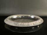 assiette en argent plaqué avec un bord perlé sur un fond noir