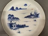 a blue and white plate with a picture of a house on it