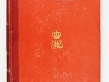 an old red book with a gold crown on top of it