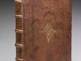 an old book with a brown cover sitting on top of a table
