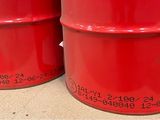 three red barrels are stacked on top of each other on a table