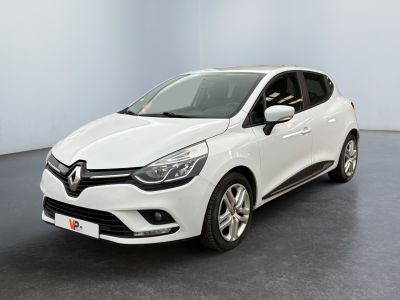 Une voiture blanche est garée dans une pièce au sol noir