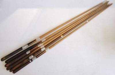 Suite de six queues de billard en bois sculpté et marqueté.