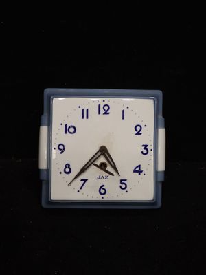 une horloge blanche avec des chiffres bleus sur un fond noir