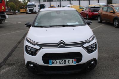 a small white car parked in a parking lot