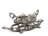 une assiette en argent décorée d'un poisson, posée sur une table