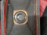 an old camera that is sitting on a red cloth