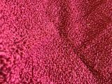 un chat allongé sur une serviette rouge