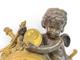 a statue of an angel holding a coin on top of a clock