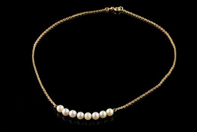un collier en or orné de perles sur fond noir