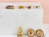 several gold rings and rings are sitting on a marble block