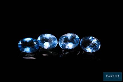 un ensemble de trois saphirs bleus posés sur une surface noire
