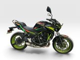 the black and green motorcycle is parked on a white surface