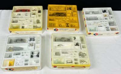 quatre boîtes contenant des articles variés, posées sur une table devant un fond noir