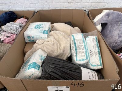une boîte en carton remplie de toutes sortes d'objets, posée par terre