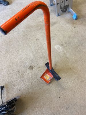 an orange pole that is on the floor next to a pair of shoes