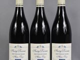 three bottles of wine are lined up on a table